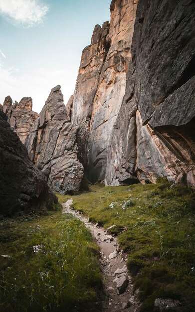 Le chemin entre les montagnes rocheuses avec les murs remplis d'herbe verte