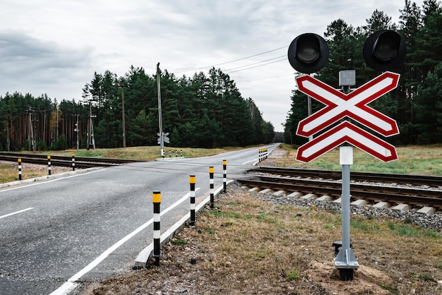 Chemin de fer local avec la route goudronnée traversant dans une campagne.