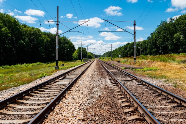 Chemin de fer pittoresque en zone rurale et ciel bleu avec des nuages blancs en été