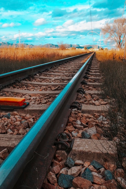 Chemin de fer vide dans la campagne contre un ciel bleu avec des nuages Concept de transport Pas de véhicule de piste Composition verticale Voyage et destination Chemin de fer en Espagne Pas de trains de circulation Ambiance saturée