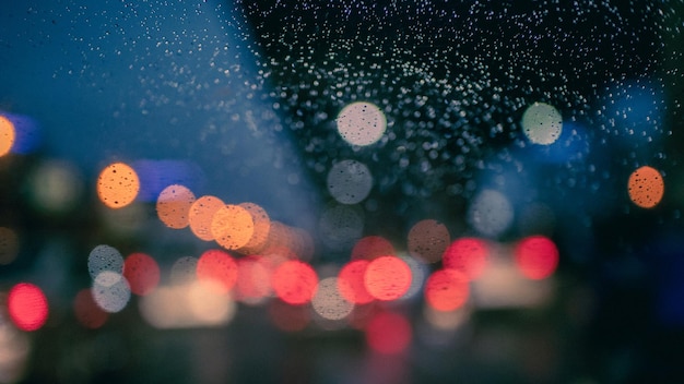 Sur le chemin avec une goutte de pluie sur le pare-brise la nuit avec embouteillage