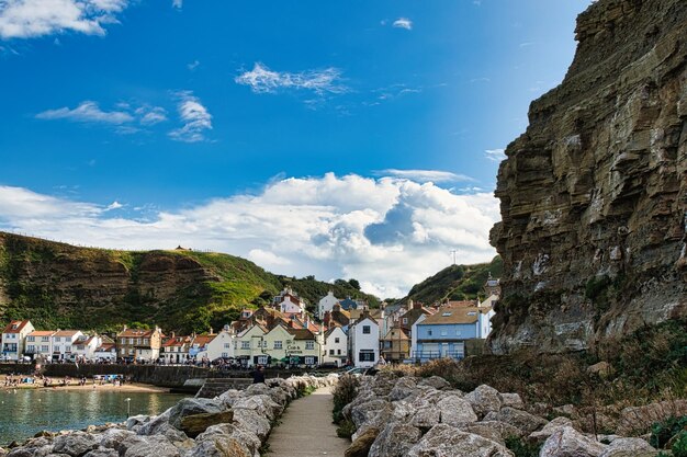 un chemin menant à la plage avec des maisons sur la falaise