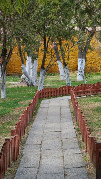 Chemin de pierre dans le jardin avec clôture rouge