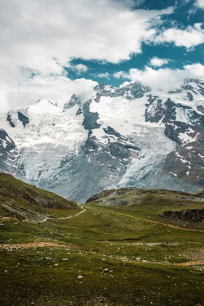 Chemin des prés verts dans les montagnes enneigées des Alpes suisses de Zermatt randonnées en Suisse Europe