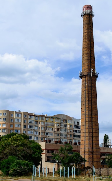 Cheminée de la chaufferie sous le ciel bleu. Image urbaine.