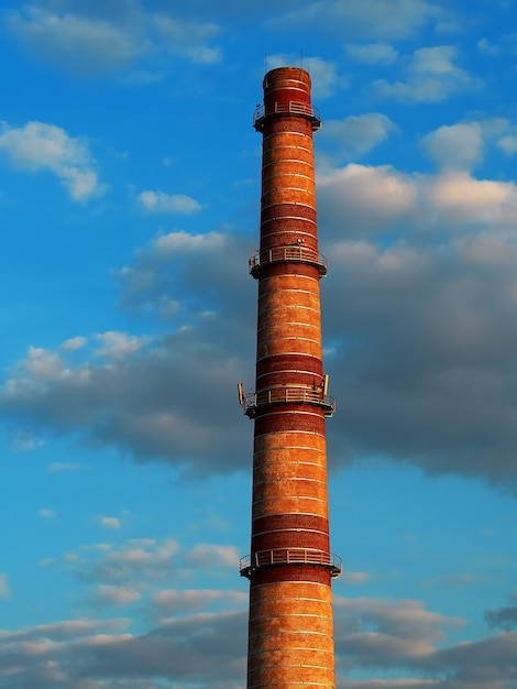 Cheminée industrielle pendant le fond dramatique de coucher du soleil