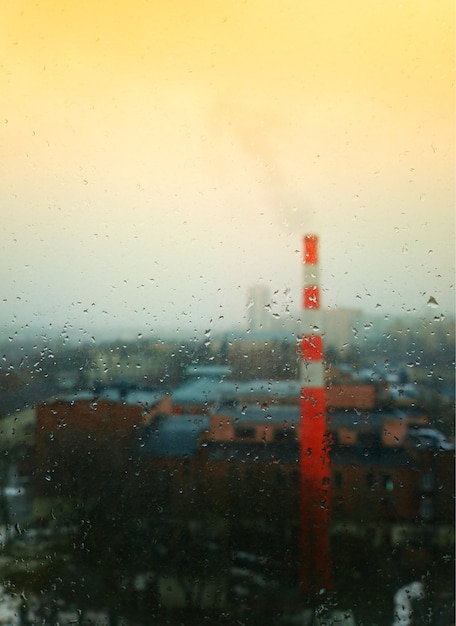 Photo cheminée industrielle à travers le fond de gouttes de pluie
