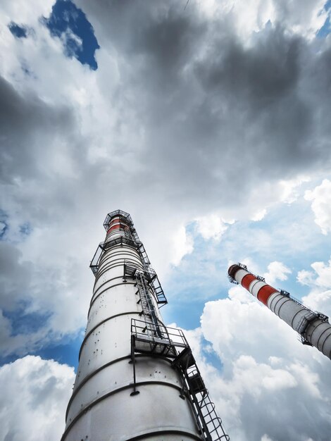 Cheminées blanches d'une centrale électrique sur fond de nuages avec des lignes diagonales