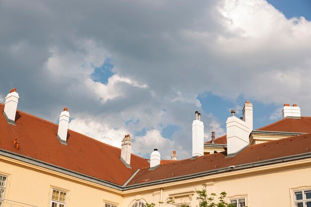 Des cheminées sur le toit de la maison contre le ciel