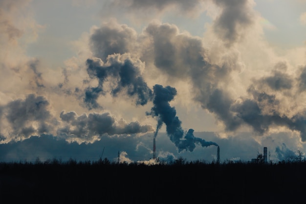 Photo les cheminées d'usine polluent l'atmosphère avec une fumée dense.