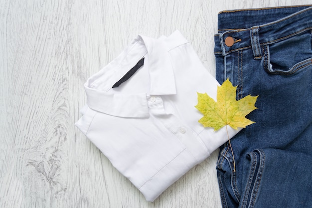 Chemise blanche, jeans et une feuille d'érable. À la mode