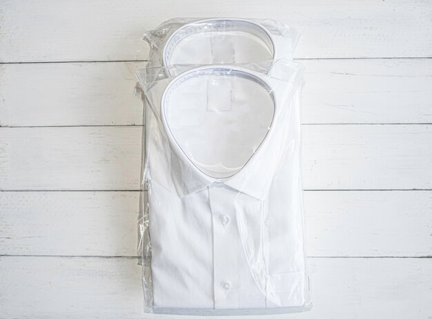 chemise blanche pliante sur fond de bois blanc