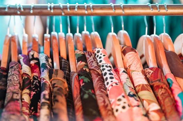 Chemise florale sur cintre suspendu au rail dans le magasin de vêtements