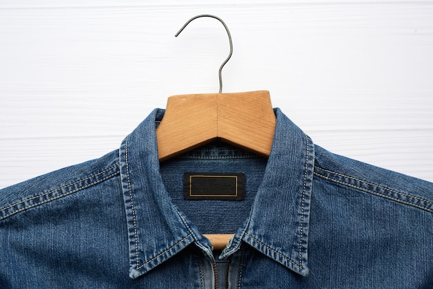 Chemise en jean accrochée à un cintre en bois