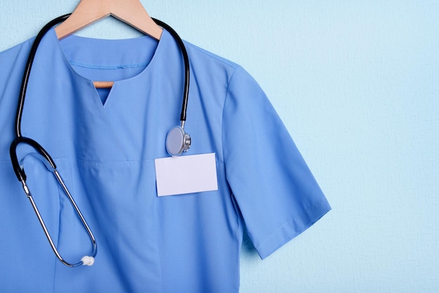 Chemise médecin avec stéthoscope sur cintre sur fond bleu