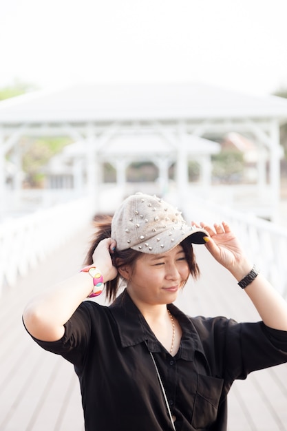 Chemise noire des femmes asiatiques. Elle porte un chapeau