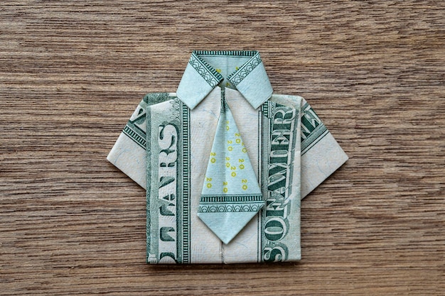 Chemise origami faite de billets de banque en dollars sur fond de bois Gros plan Dollar bill Tshirt