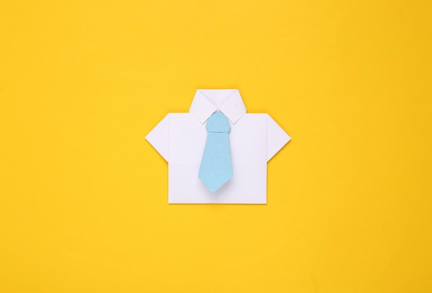 Chemise en papier origami avec cravate sur fond jaune Concept d'entreprise