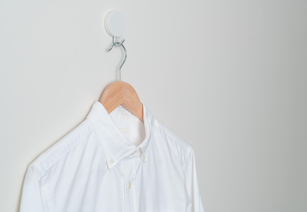 chemise suspendue avec cintre en bois au mur