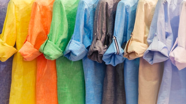 Chemises en lin Vêtements de mode sur un porte-vêtements Gros plan du choix de couleurs arc-en-ciel de vêtements féminins à la mode Garde-robe d'été