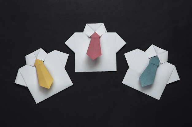 Chemises origami avec cravates sur fond noir Concept d'entreprise de travail d'équipe de leadership