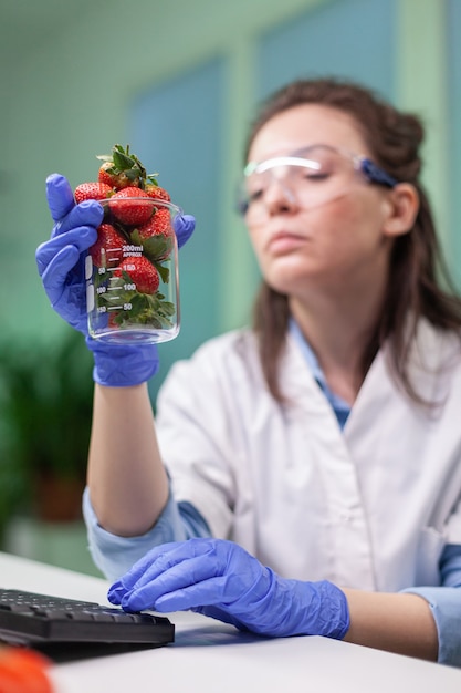 Chercheur biologiste regardant la fraise biologique examinant les fruits