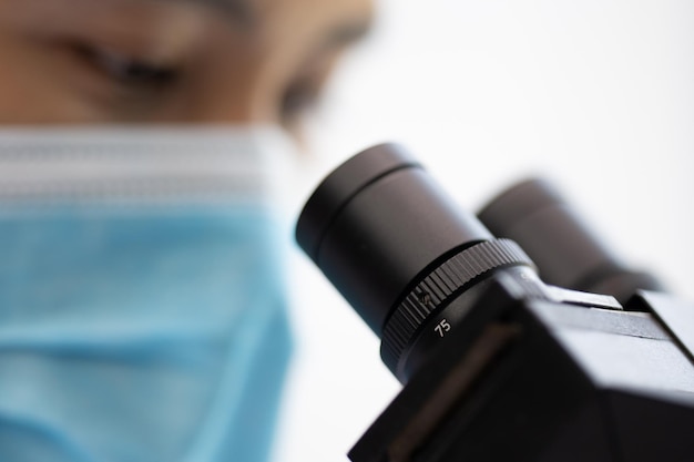 Chercheur professionnel utilisant un microscope en laboratoire de chimie scientifique technologie médicale pour la biologie ou la microbiologie découverte de la médecine équipement scientifique pour l'expérimentation en laboratoire hospitalier