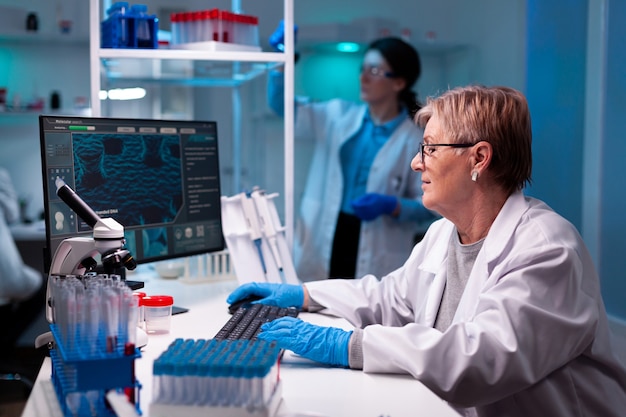 Photo chercheur scientifique principal en ingénierie de vaccins avec équipe dans une installation chimique de pharmacologie