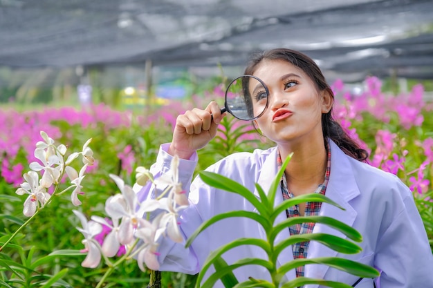 Des chercheurs, de jeunes femmes vêtues de robes blanches vérifiant des orchidées