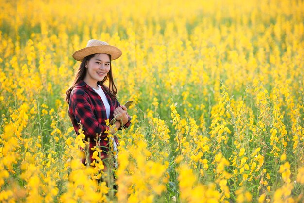 Une chercheuse agricole examine des plantes qui peuvent être cultivées pour nourrir le sol et avoir de belles fleurs en Asie