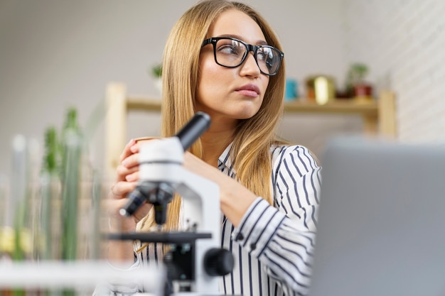 Chercheuse à son bureau avec microscope