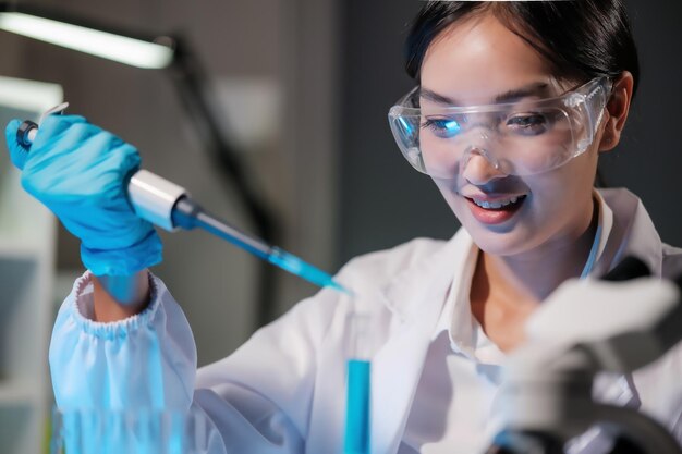 Photo une chercheuse utilise des tubes d'essai remplis de micropipettes dans un laboratoire moderne