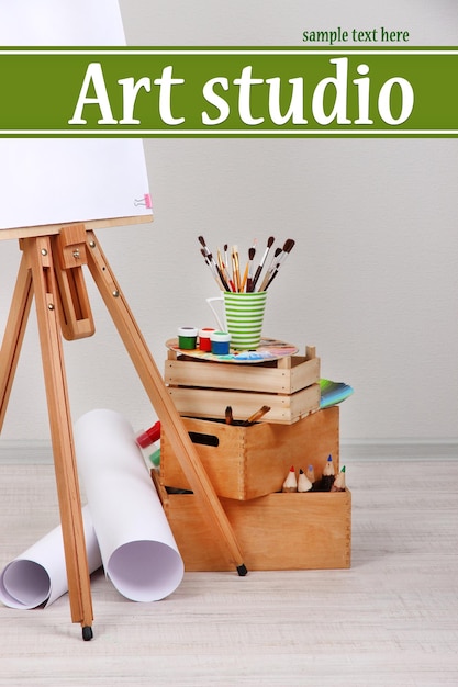 Chevalet en bois avec du papier propre et des fournitures d'art dans la pièce