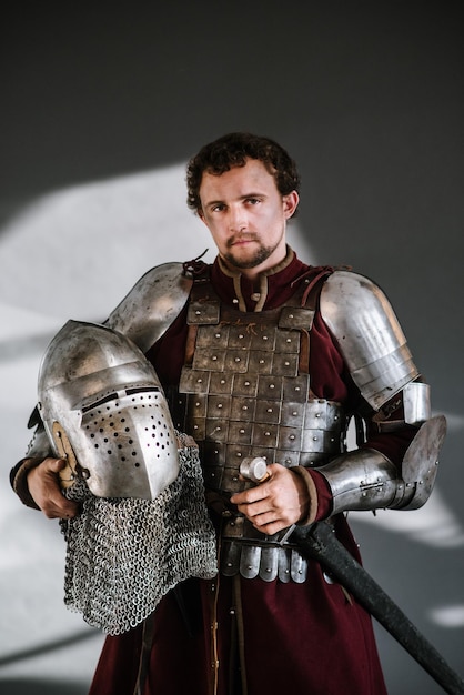 Chevalier médiéval en armure et arme sur fond sombre. Portrait du chevalier