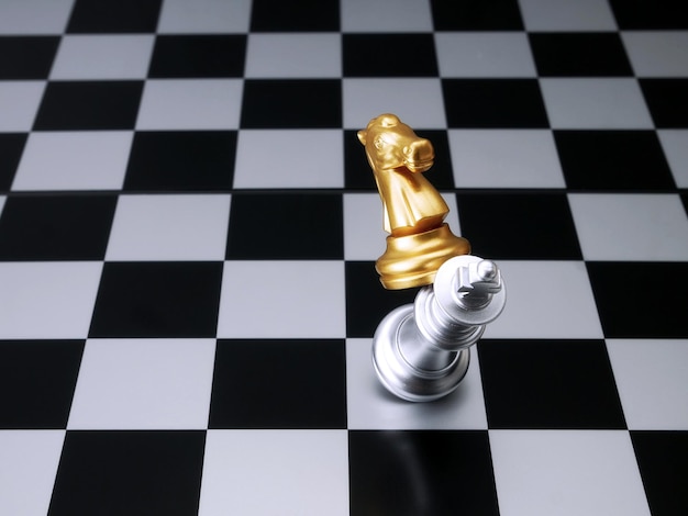 Chevalier d'or attaque d'échecs roi d'argent Concepts de leadership d'échecs
