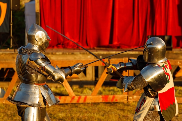 Photo des chevaliers en armure médiévale se battent lors du tournoi en été. photo de haute qualité
