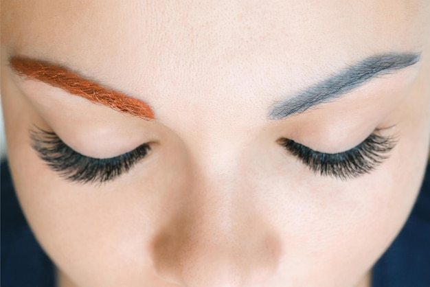 Chevauchement de maquillage permanent infructueux sur les sourcils. Appliquer un ton chaud à une couleur bleue froide. L'esthéticienne fait un maquillage permanent des sourcils sur le visage d'une belle jeune femme.