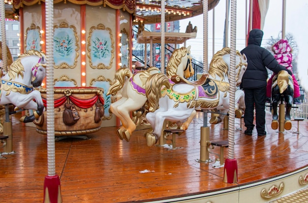 Chevaux de carrousel à l'ancien carnaval les gens s'amusent à Noël