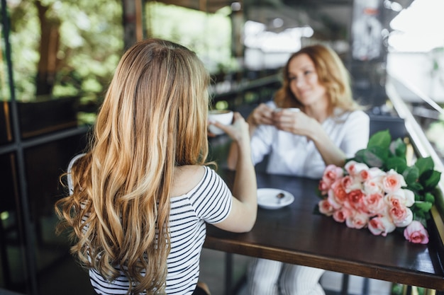 Les cheveux de la belle jeune fille blonde à l'arrière sur la terrasse d'été cafealk.