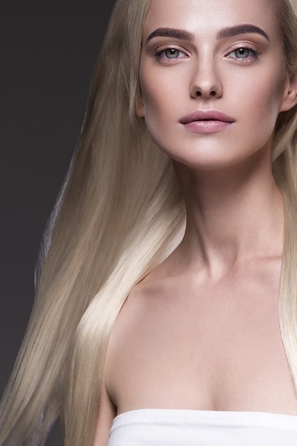 Cheveux blonds femme longue coiffure lisse beauté portrait féminin. Sur noir.
