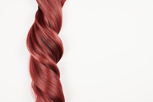 Cheveux brillants à l'aspect naturel, bouquet de boucles rouges isolées sur fond blanc avec espace de copie
