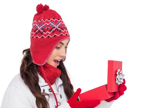 Cheveux bruns heureux ouvrant le cadeau de Noël