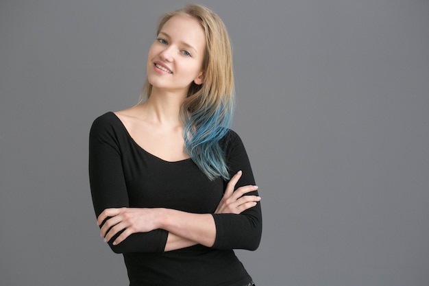 Cheveux de couleur femme avec une coiffure de couleur bleue sur un mur gris. Prise de vue en studio.