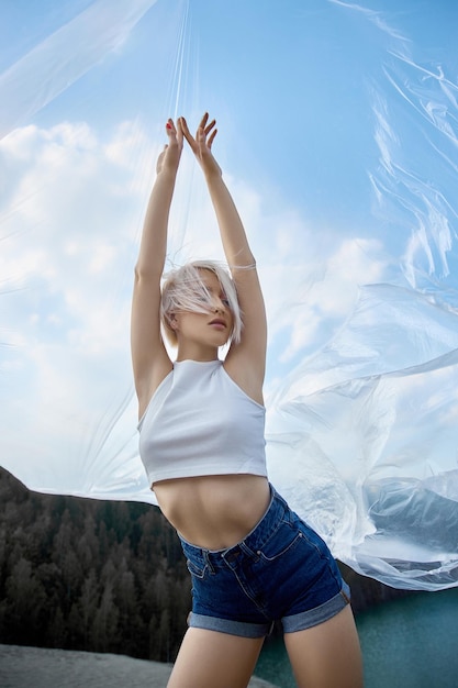 Cheveux courts de femme blonde parfaite. Mode femme pose en été dans la nature par une journée ensoleillée. Manucure ongles rouges