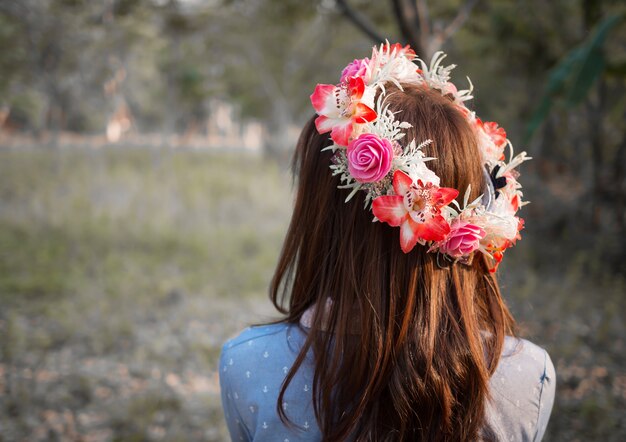 Cheveux femme avec une couronne de fleur dans le paysage de la nature