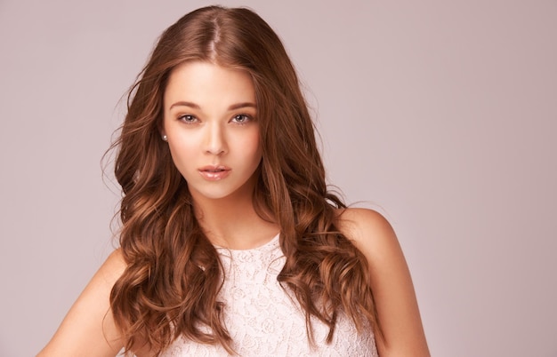 Cheveux glamour et beauté naturelle Superbe jeune brune sur fond rose