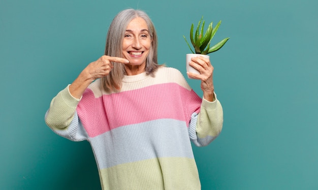 Cheveux gris jolie femme avec un cactus