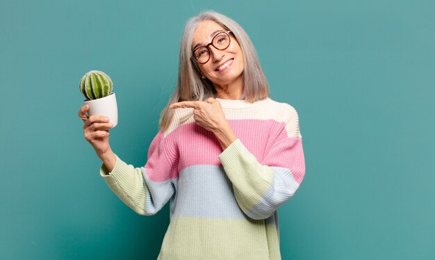 Cheveux gris jolie femme avec un cactus