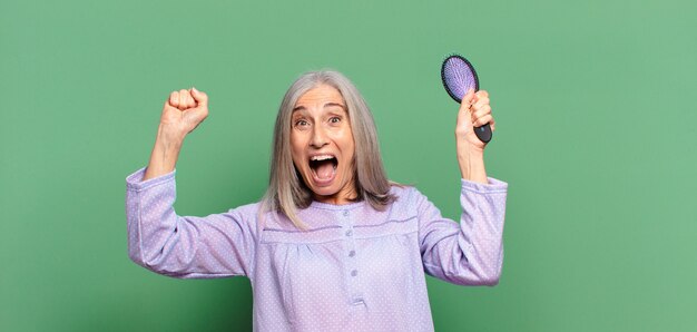 Cheveux gris jolie femme se réveillant et portant un pyjama