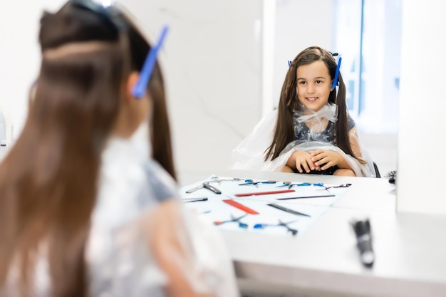 Les cheveux de la jolie jeune fille sont arrangés chez le coiffeur